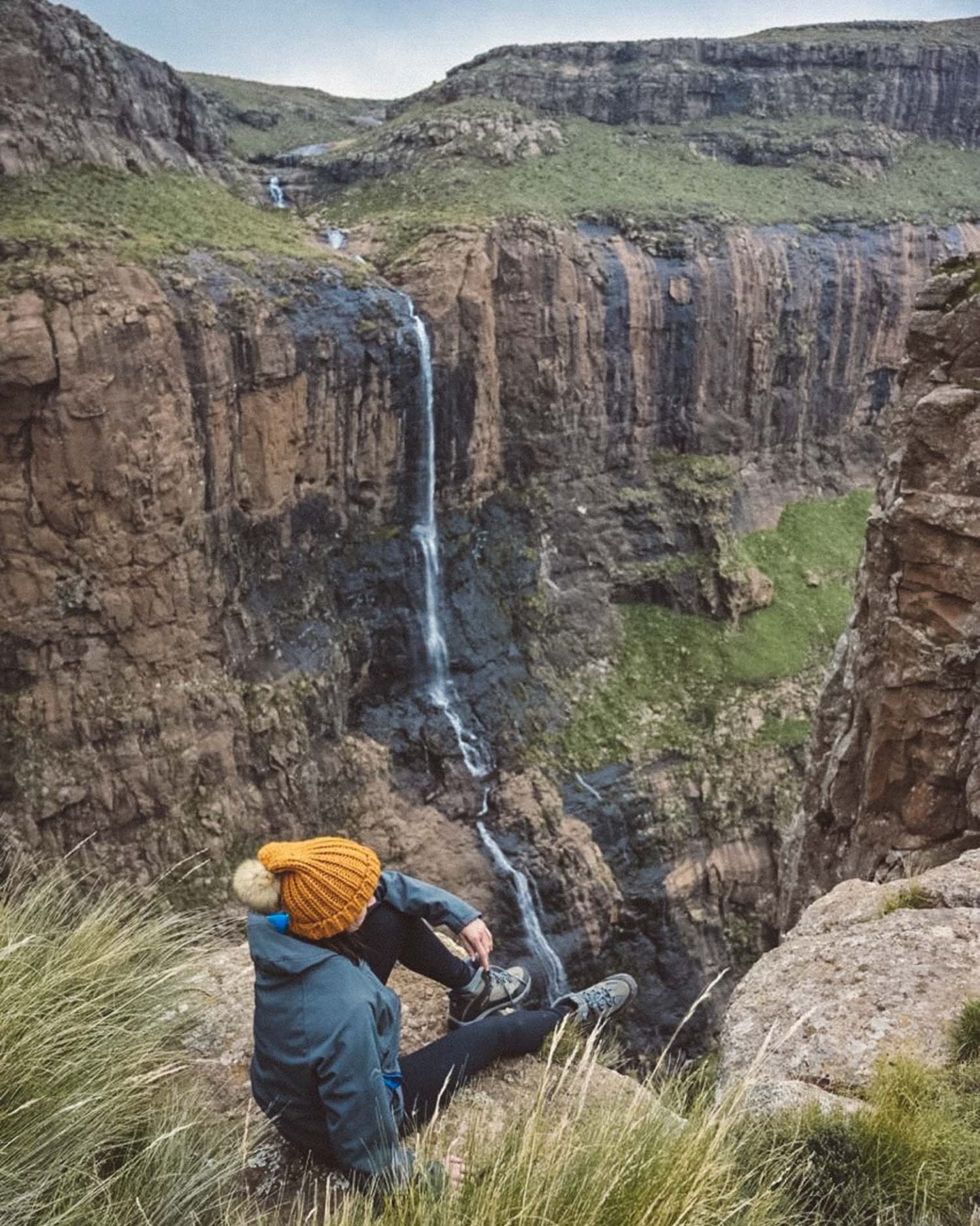 girl sitting by waterfall