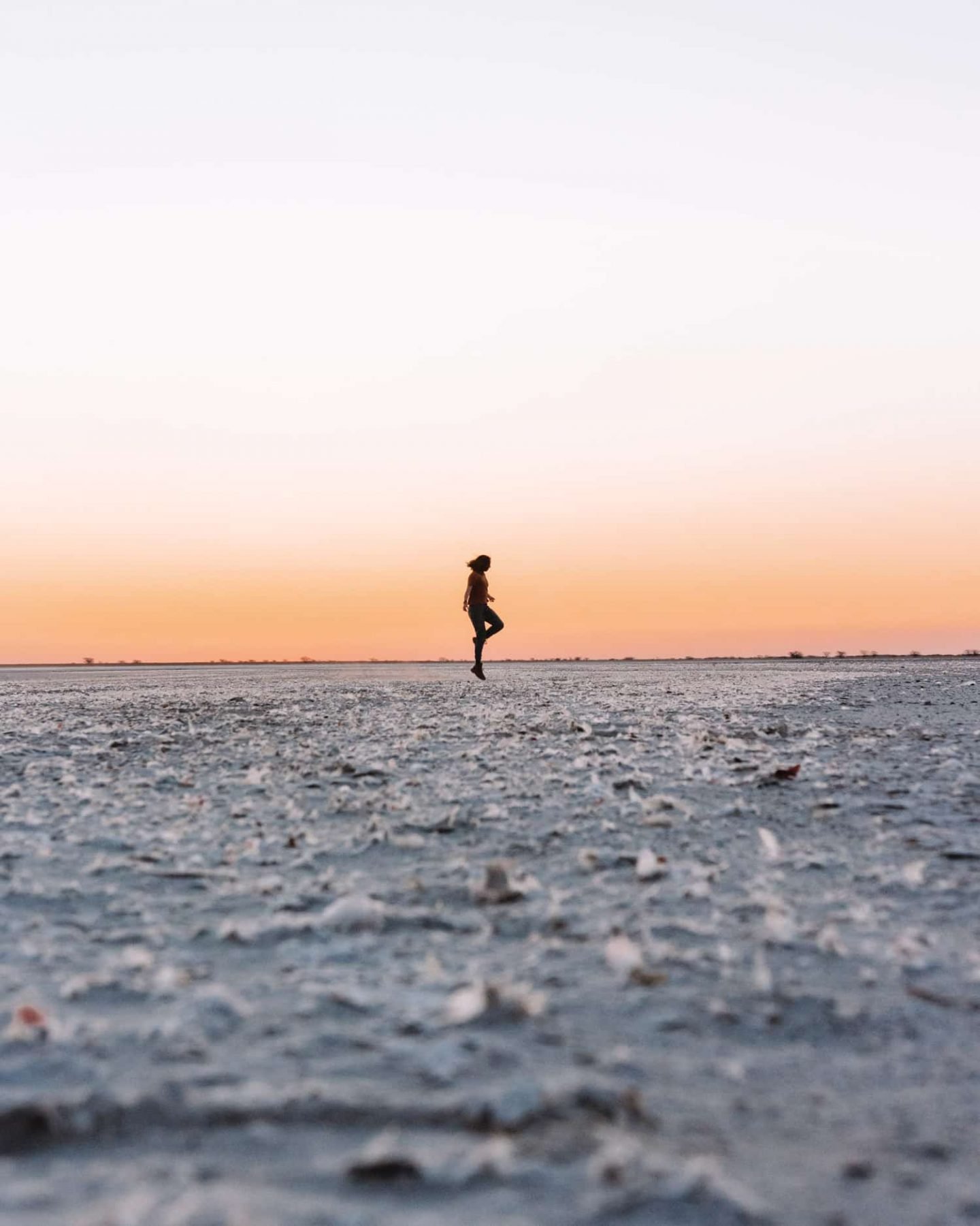 girl standing on salt pan in botswana