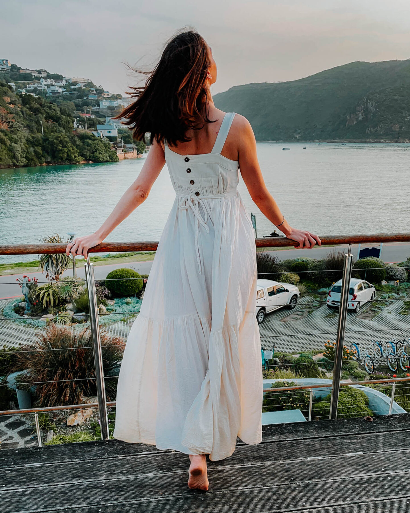 girl standing on a deck at sunset