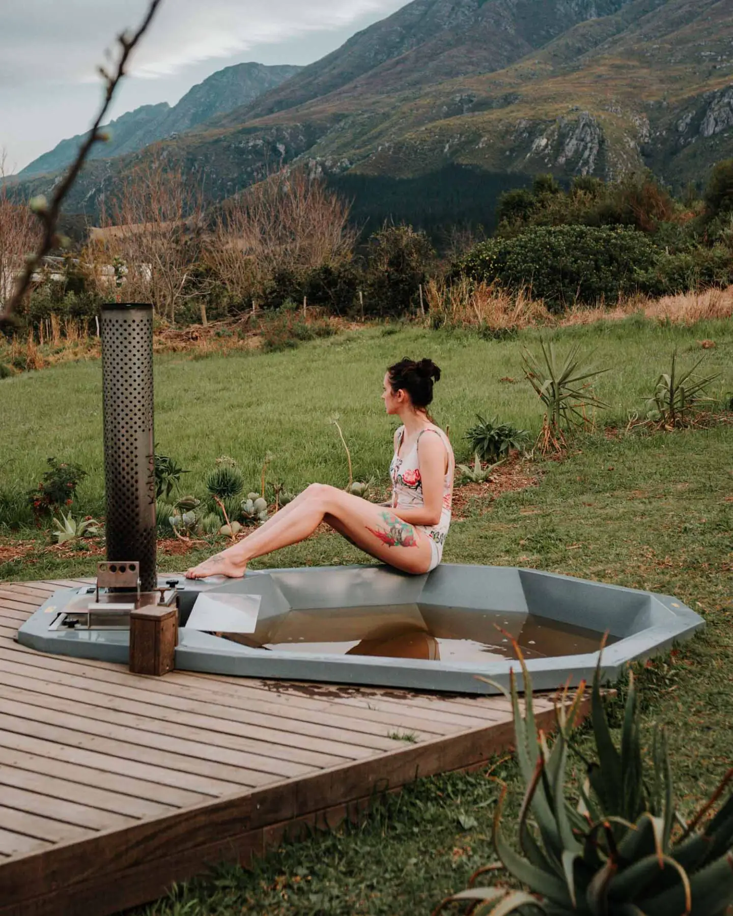 girl sitting next to woodfire hot tub