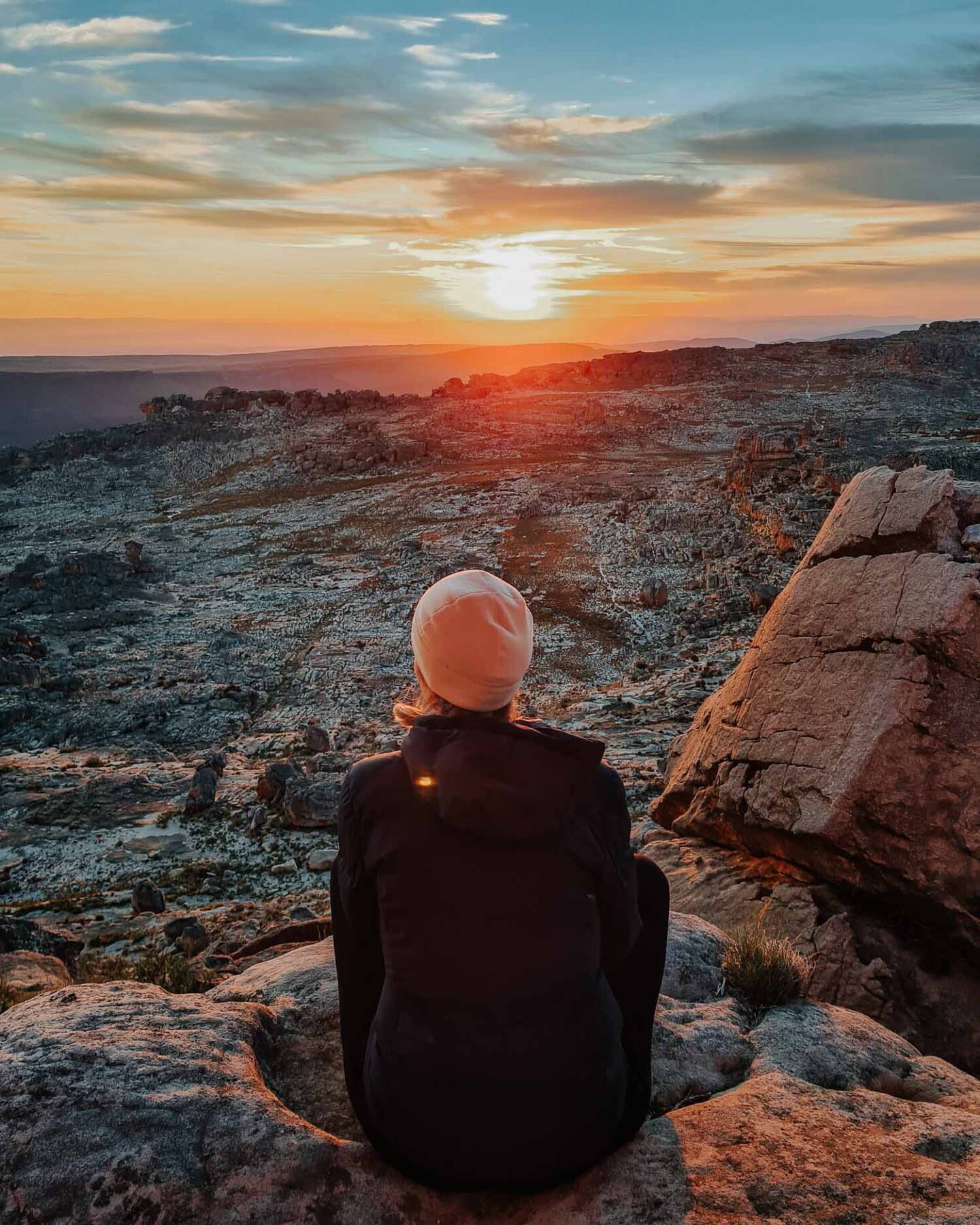 woman watching sunrise on top of wolfberg arch
