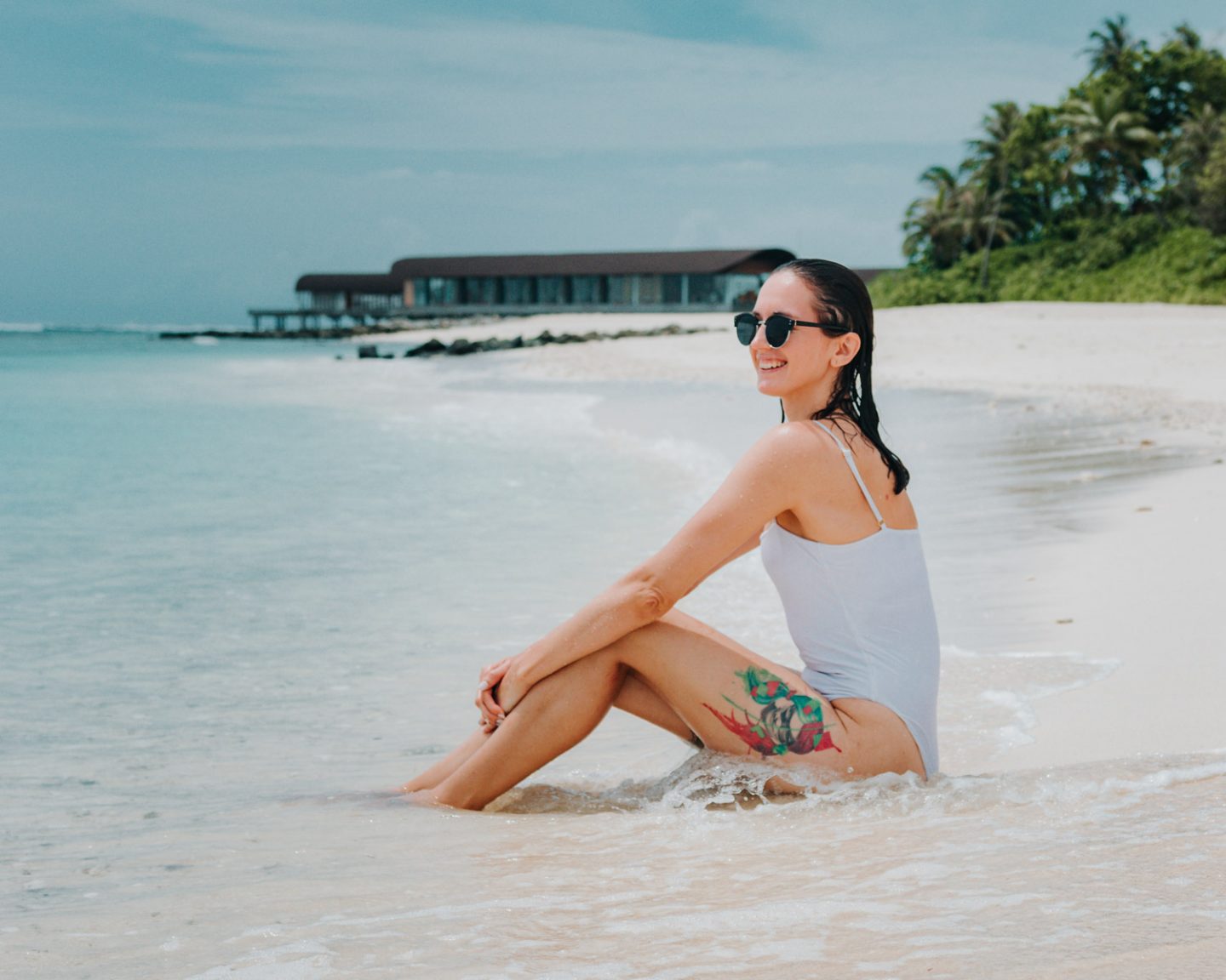 girl sitting on beach in the maldives