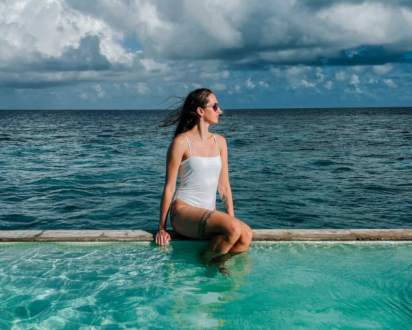 girl sitting on edge of pool