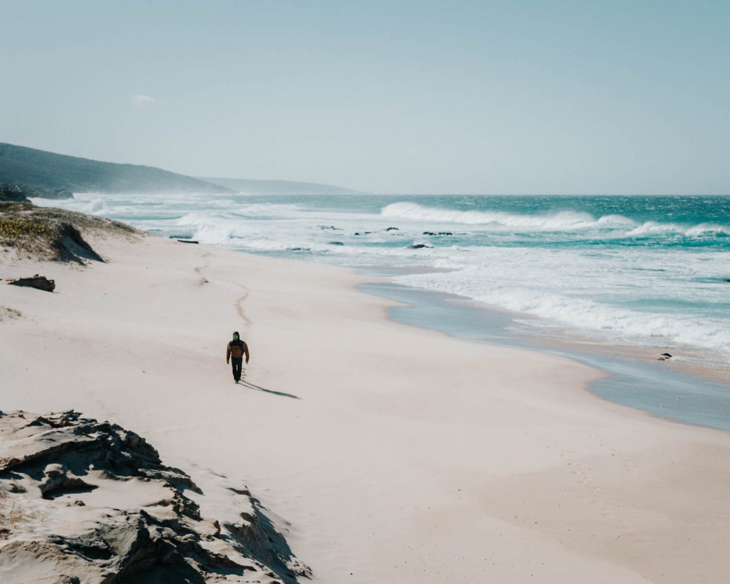 man hiking on a beach