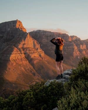 lauren on top of lions head at sunset with table mountain in the background